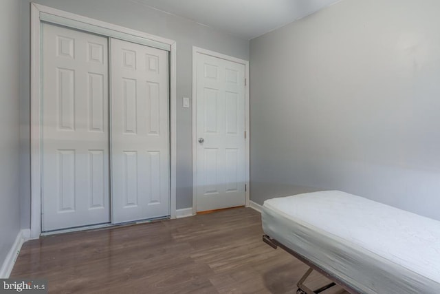 bedroom with a closet, baseboards, and wood finished floors