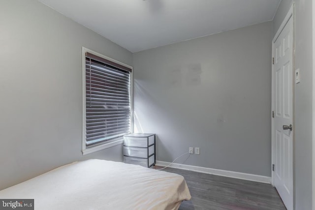 bedroom featuring baseboards and wood finished floors