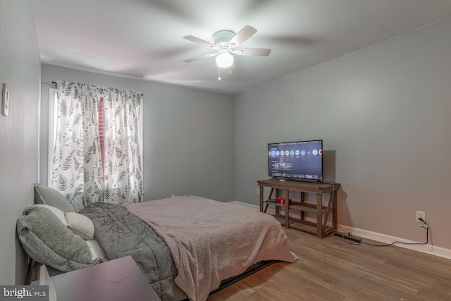 bedroom with ceiling fan, baseboards, and wood finished floors