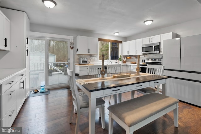 502 Dembytown Rd, Joppa, MD 21085 - kitchen with dark wood finished floors, white cabinets, light countertops, stainless steel appliances, and decorative backsplash