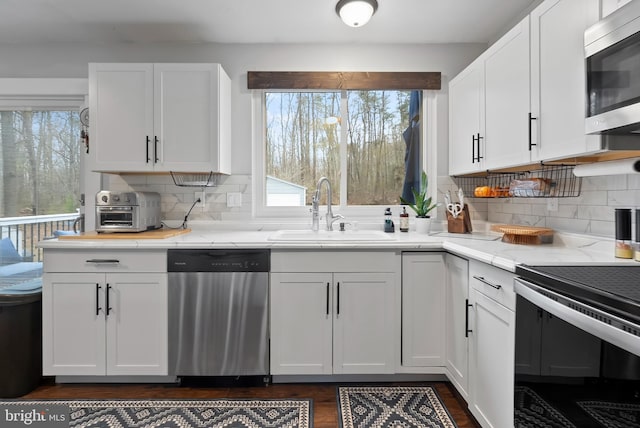 502 Dembytown Rd, Joppa, MD 21085 - kitchen featuring white cabinets, tasteful backsplash, a sink, and appliances with stainless steel finishes