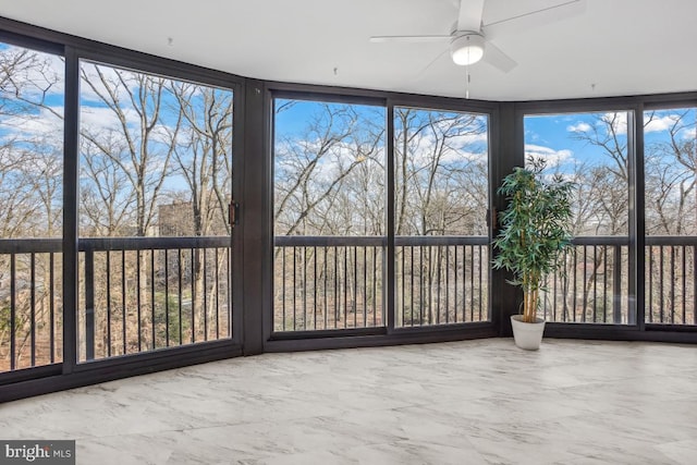 unfurnished sunroom featuring a ceiling fan