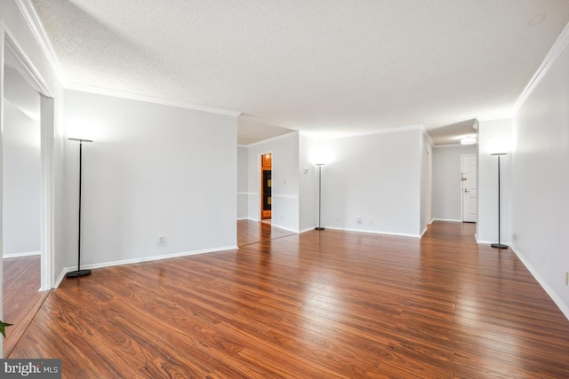 unfurnished room featuring a textured ceiling, crown molding, baseboards, and wood finished floors