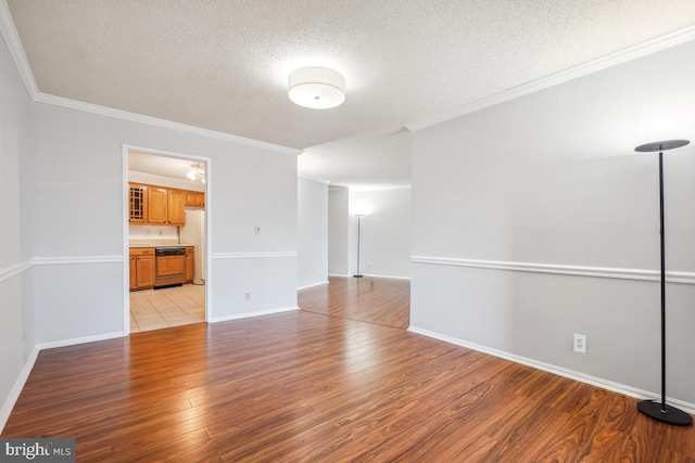 unfurnished room featuring baseboards, a textured ceiling, crown molding, and light wood-style floors