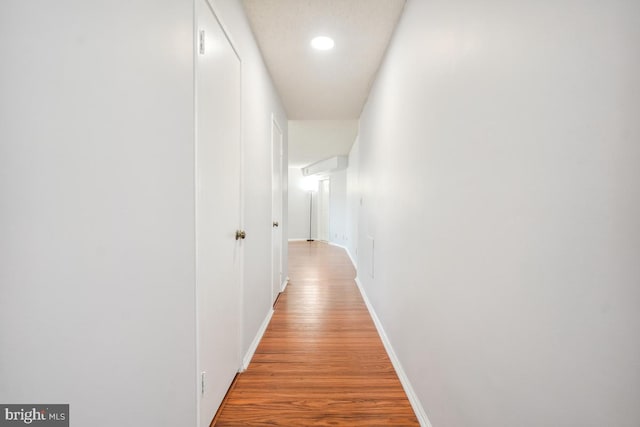 hallway with recessed lighting, baseboards, and light wood-style floors