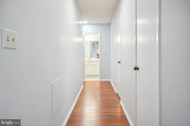 hall with baseboards and wood finished floors