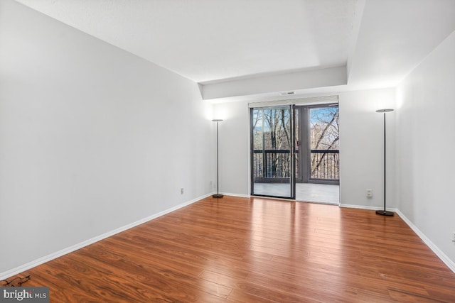 unfurnished room with baseboards and wood finished floors