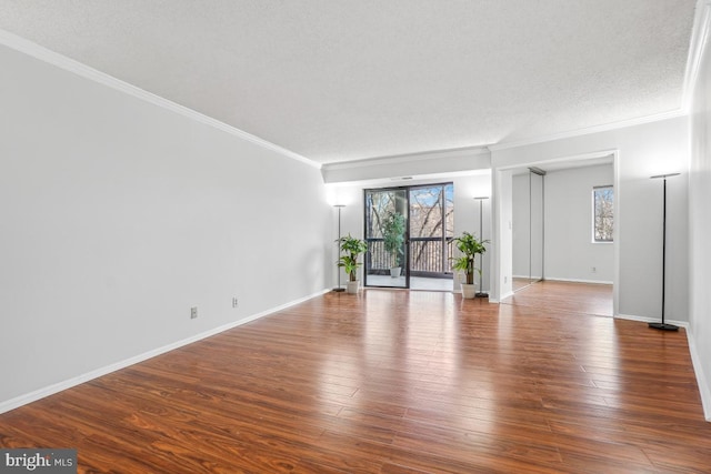 spare room with ornamental molding, baseboards, and hardwood / wood-style flooring