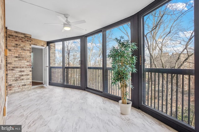 unfurnished sunroom featuring plenty of natural light and a ceiling fan