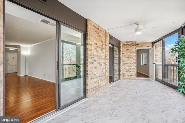 unfurnished sunroom featuring a ceiling fan and visible vents