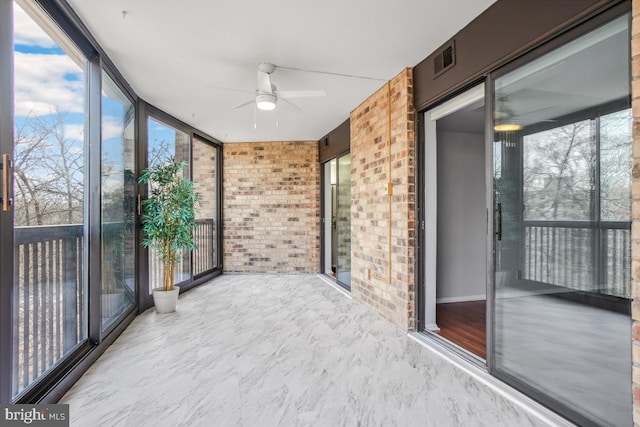 unfurnished sunroom featuring plenty of natural light, visible vents, and ceiling fan