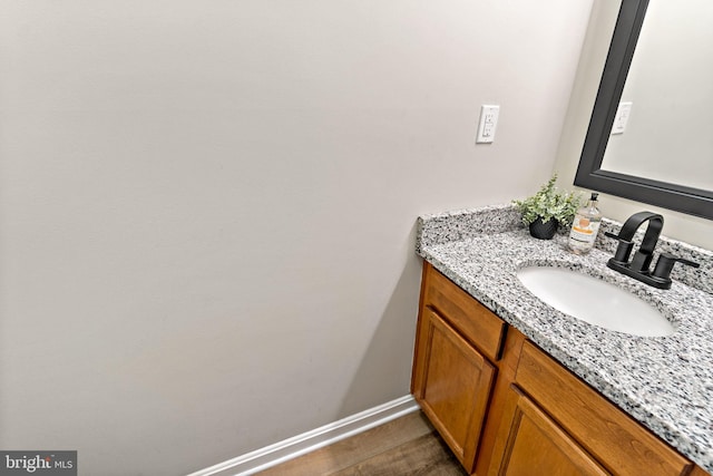 bathroom featuring vanity, baseboards, and wood finished floors