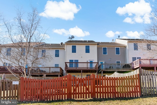 rear view of house featuring fence private yard and a wooden deck