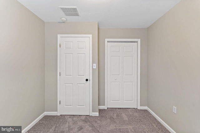 unfurnished bedroom with a closet, visible vents, baseboards, and carpet floors