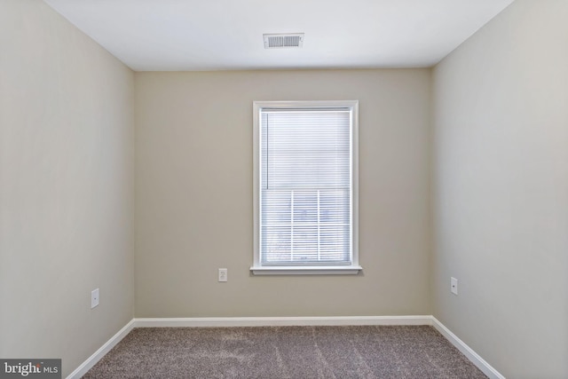 carpeted empty room with visible vents and baseboards