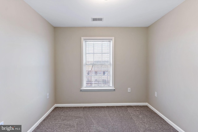 carpeted empty room featuring baseboards and visible vents