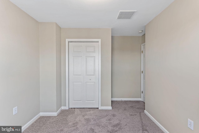 unfurnished bedroom with a closet, baseboards, visible vents, and carpet floors