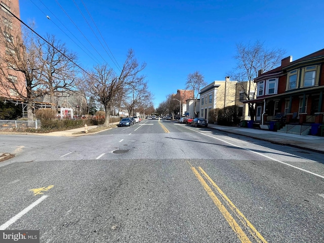 view of street with sidewalks, a residential view, and curbs