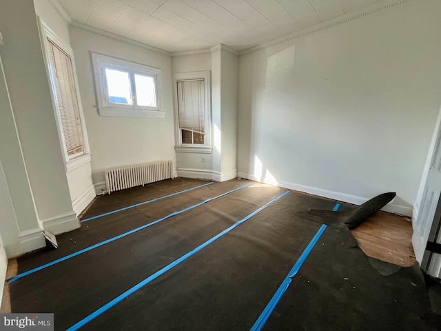 unfurnished bedroom with crown molding, radiator, and baseboards