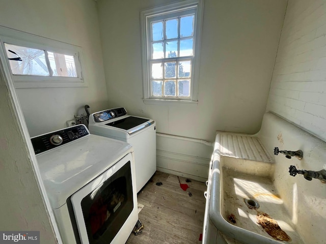 washroom featuring laundry area, washing machine and dryer, and light wood-style floors