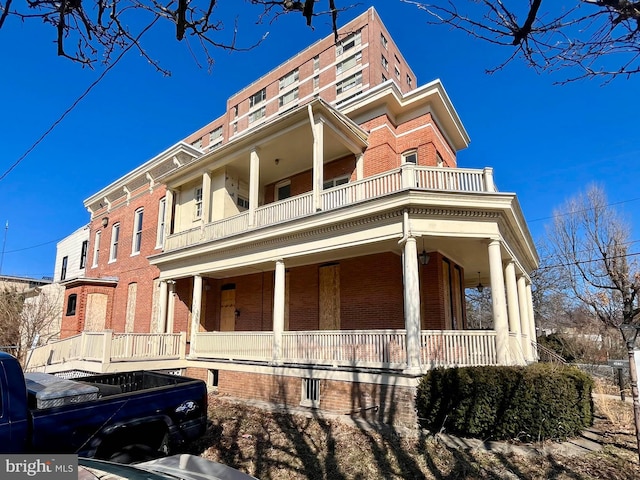 view of home's exterior featuring brick siding and a porch