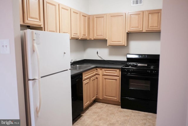 kitchen with dark countertops, visible vents, light tile patterned flooring, black appliances, and a sink