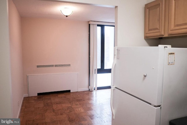 kitchen featuring a wealth of natural light, baseboards, and freestanding refrigerator