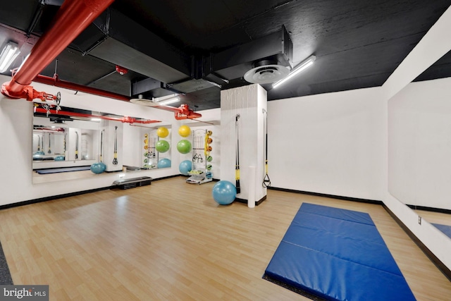 gym with visible vents, baseboards, and wood finished floors