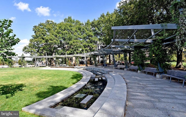 view of property's community with a yard and a pergola