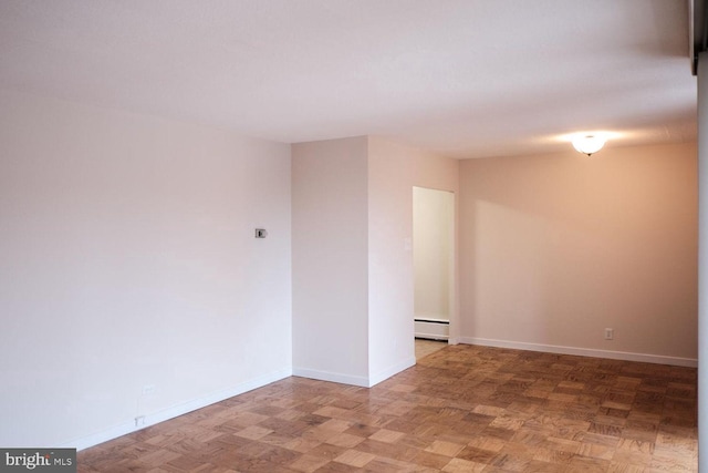 empty room featuring a baseboard heating unit and baseboards