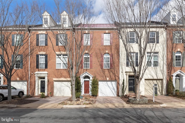 townhome / multi-family property featuring brick siding and driveway