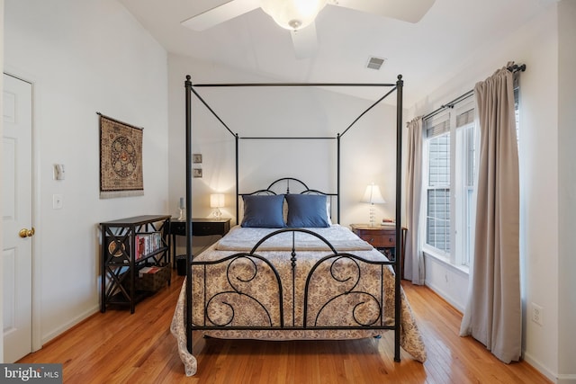 bedroom featuring baseboards, visible vents, and light wood finished floors