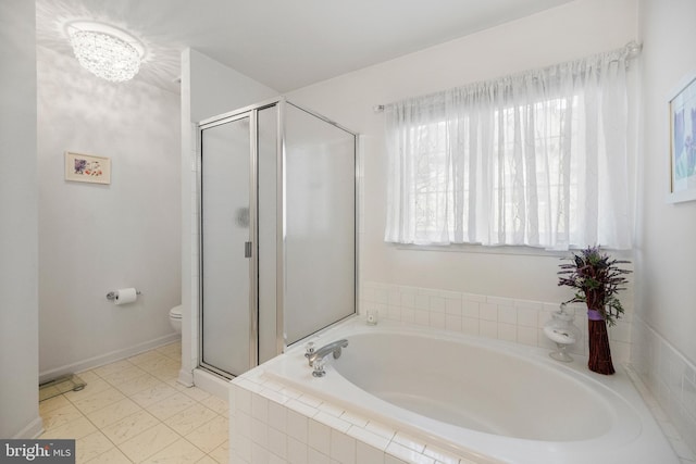 bathroom featuring a wealth of natural light, a garden tub, a stall shower, and toilet