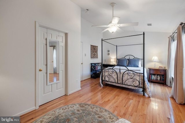 bedroom featuring a ceiling fan, baseboards, visible vents, vaulted ceiling, and light wood-type flooring