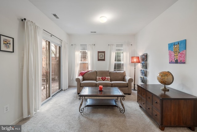 living area featuring visible vents and light carpet