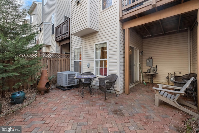 view of patio / terrace featuring central air condition unit, a balcony, and fence