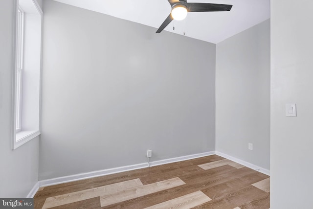 spare room featuring wood finished floors, baseboards, and ceiling fan