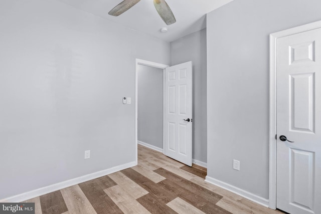 unfurnished bedroom with ceiling fan, baseboards, and wood finished floors