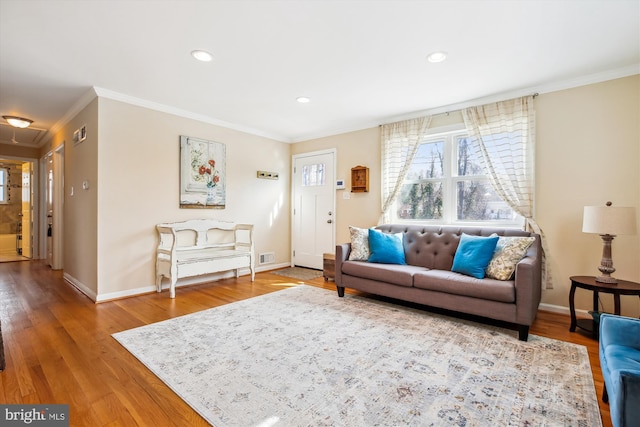 living area featuring wood finished floors, baseboards, and ornamental molding