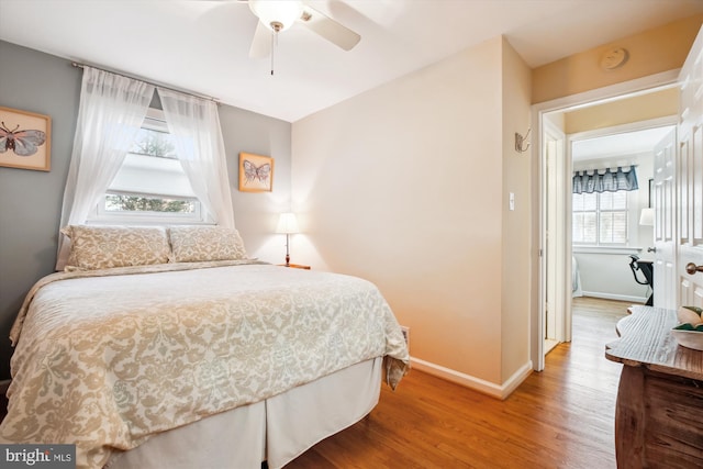 bedroom with wood finished floors, baseboards, and ceiling fan