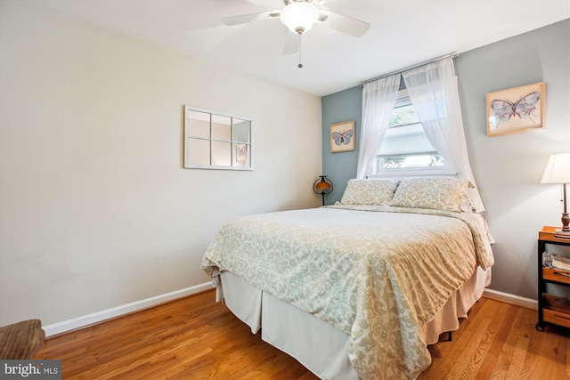 bedroom with ceiling fan, baseboards, and wood finished floors