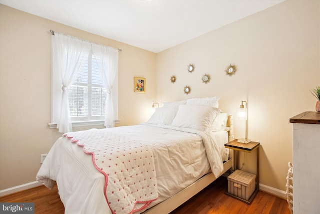 bedroom with baseboards and wood finished floors