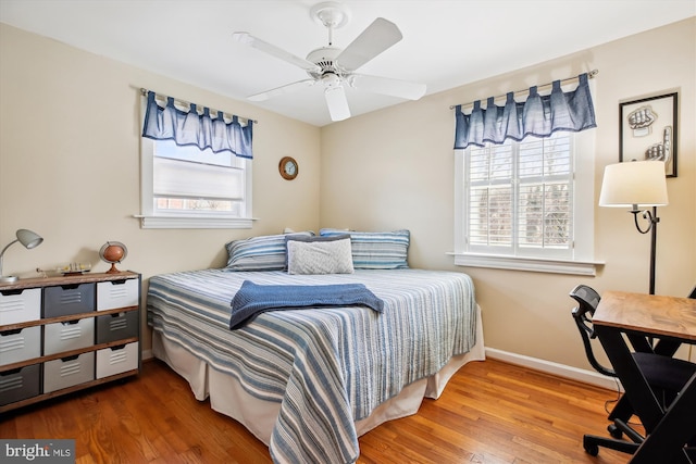 bedroom featuring ceiling fan, baseboards, and wood finished floors