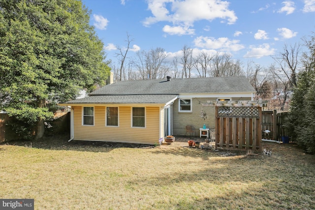 back of property featuring a shingled roof, a lawn, a chimney, and fence