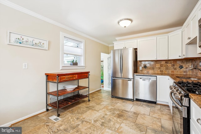 kitchen with visible vents, a sink, backsplash, white cabinetry, and stainless steel appliances