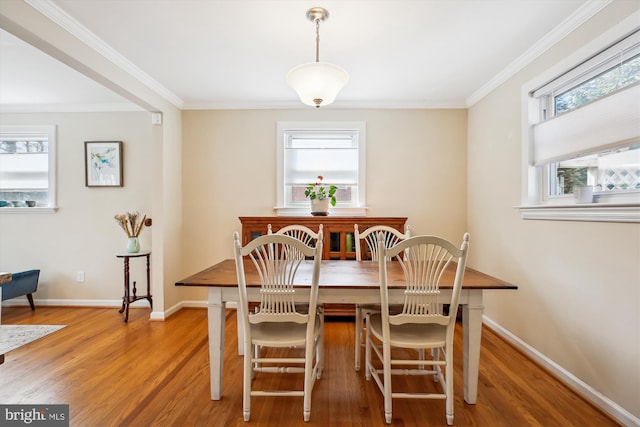 dining room with crown molding, baseboards, and wood finished floors