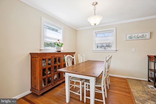 dining room with baseboards, light wood-style floors, and crown molding