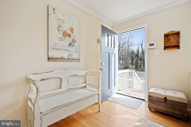 doorway featuring crown molding and wood finished floors