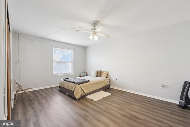 bedroom featuring wood finished floors, baseboards, and ceiling fan