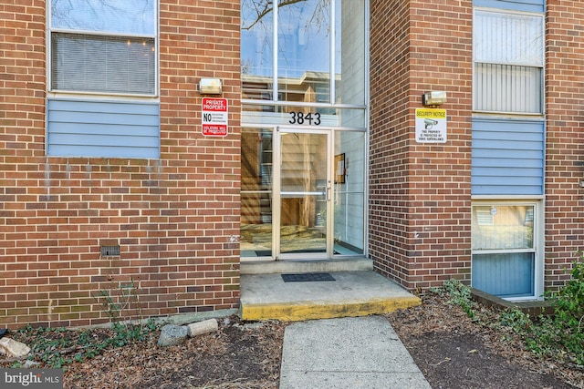 property entrance featuring brick siding